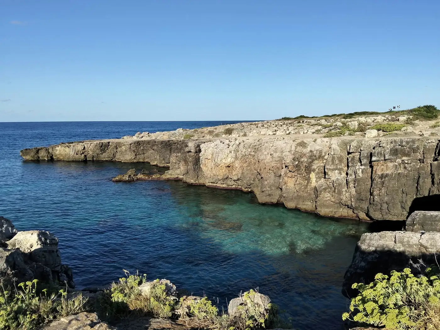 Cala dall'acqua turchese lungo la scogliera tra Posto Rosso e Capilungo